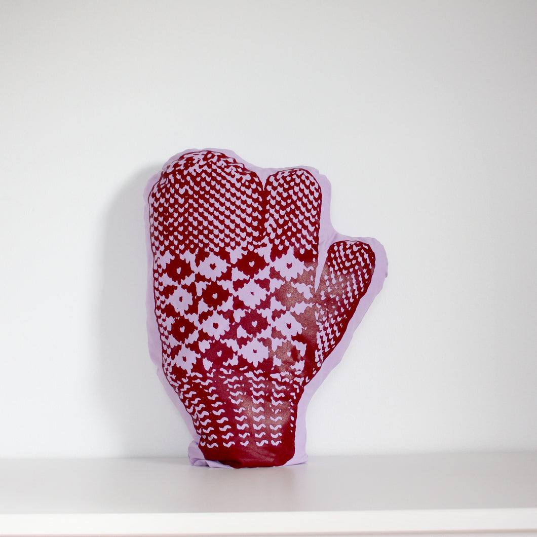Purple trigger mitten pillow with red print.